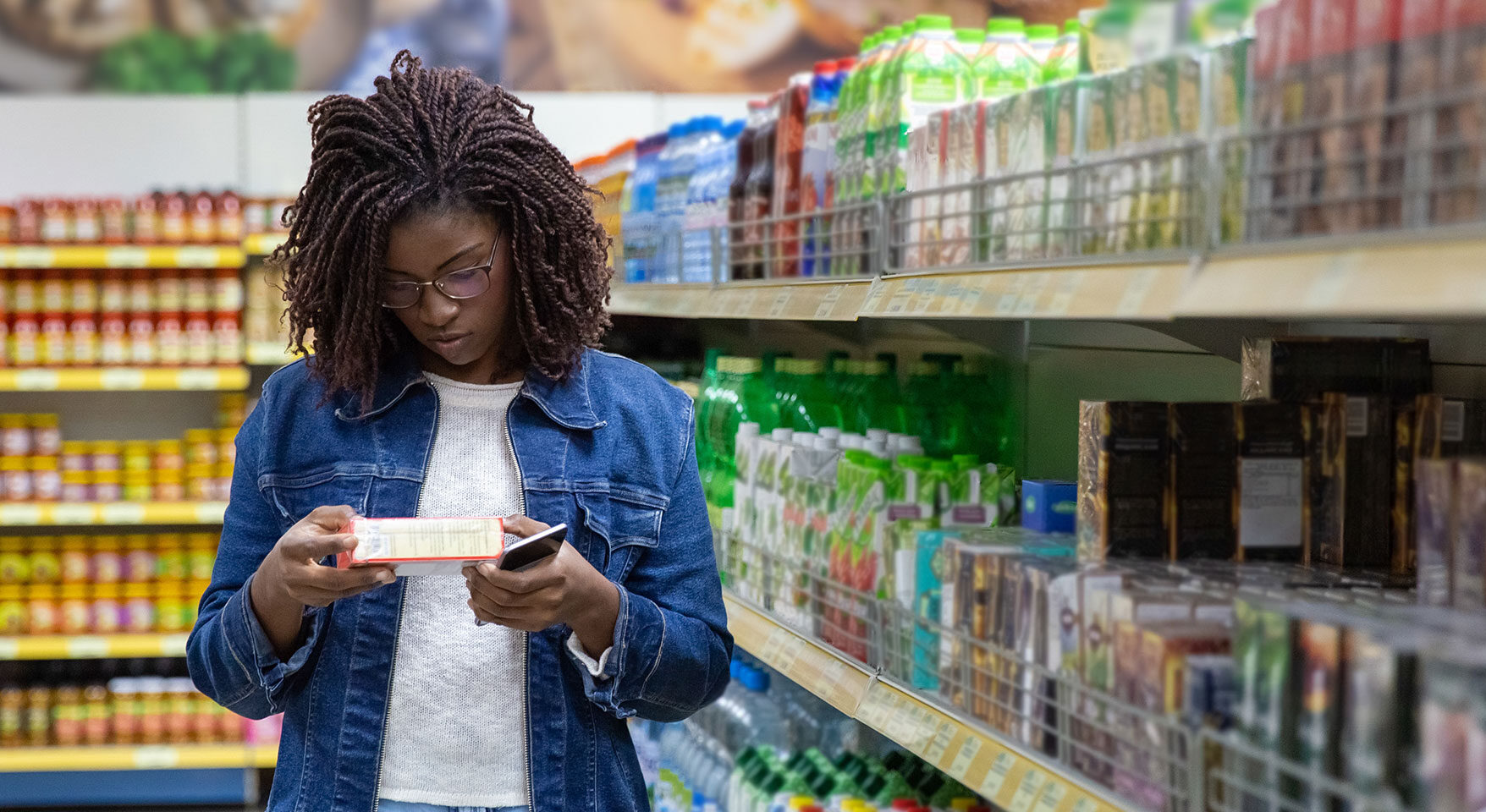 woman reading a label in the supermarket aisle