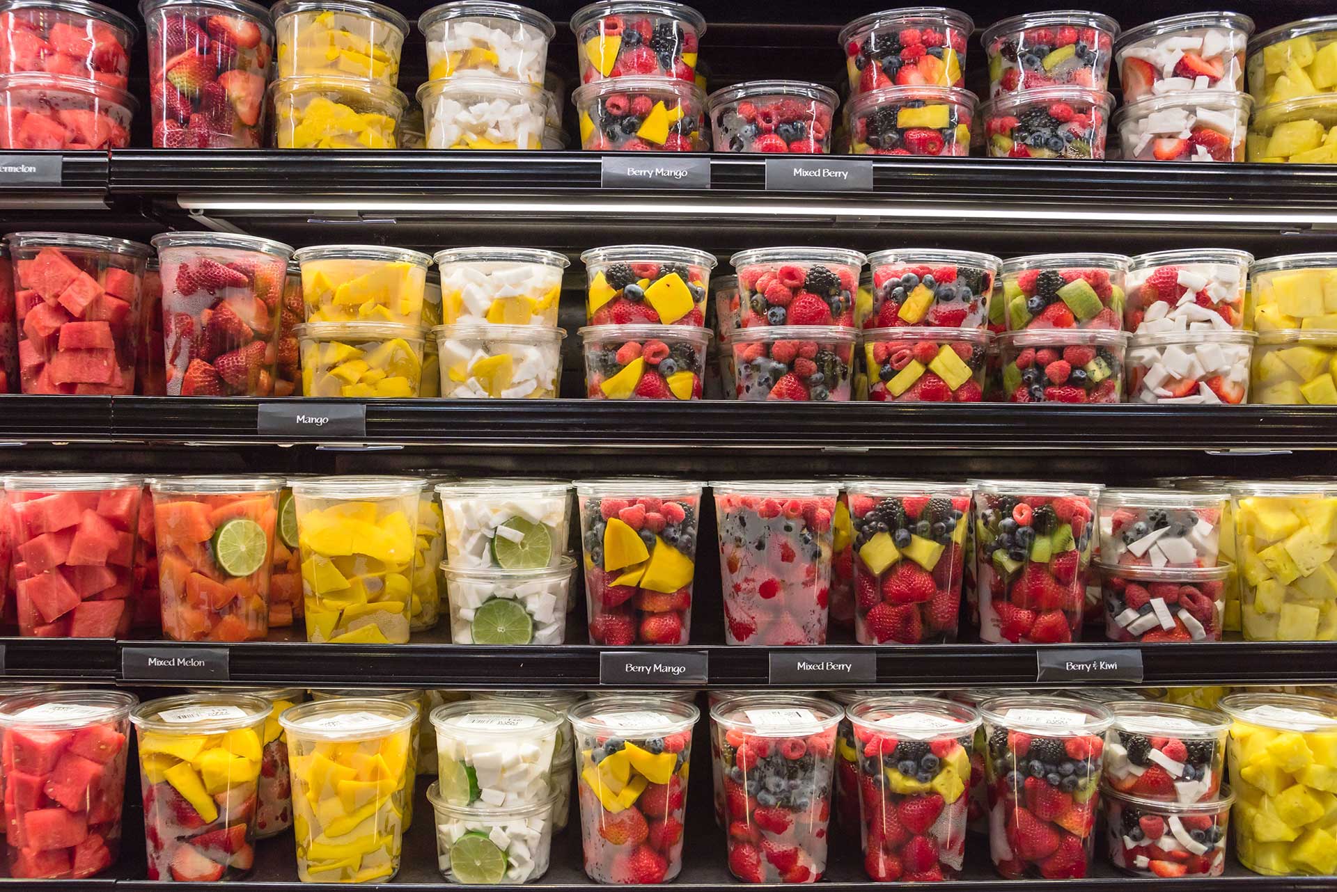 fresh fruit in plastic containers on grocery shelves